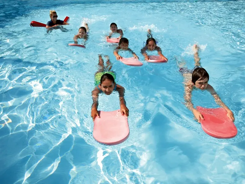 Group of children practising kicks on kickboards